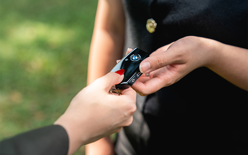 One person handing over digital car keys to another.