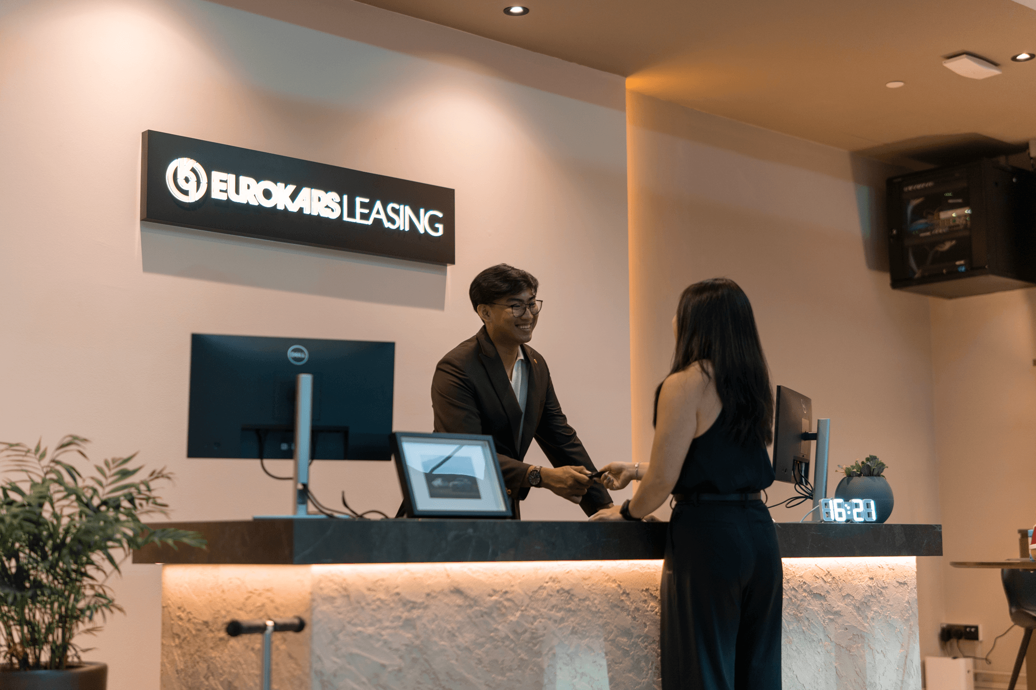 Rental Experience Ambassador assisting a customer at the service counter during vehicle collection.