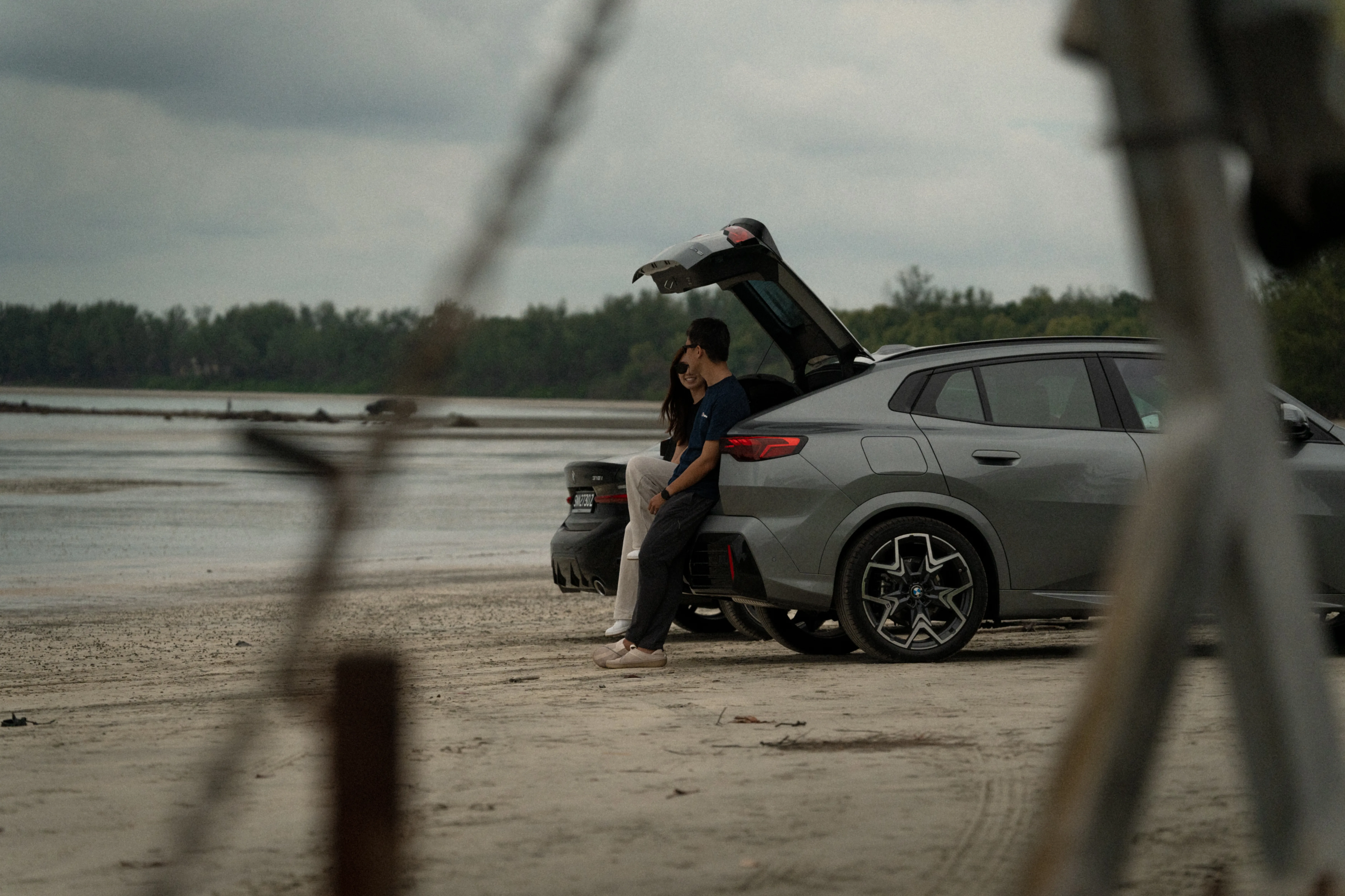 Couple relaxing by the beach with their long term leased BMW SUV