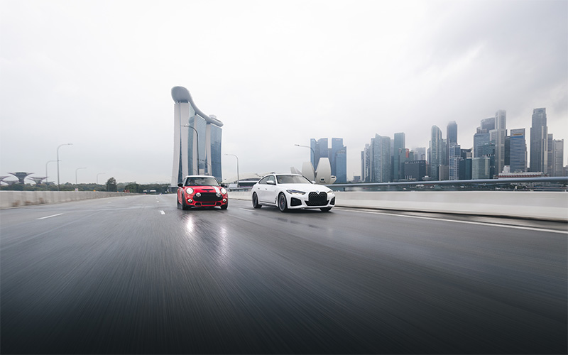 two luxury cars driving along marina bay sands